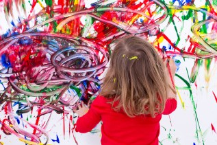 Young Kid Painting Abstract On White Wall